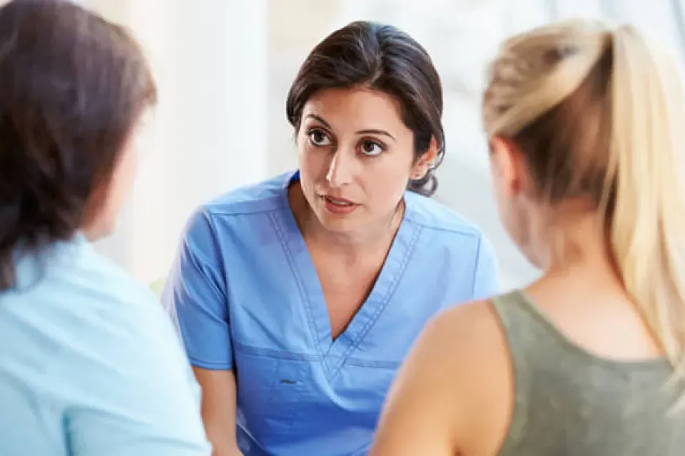 Registered nurse discussing diagnosis with mother and daughter